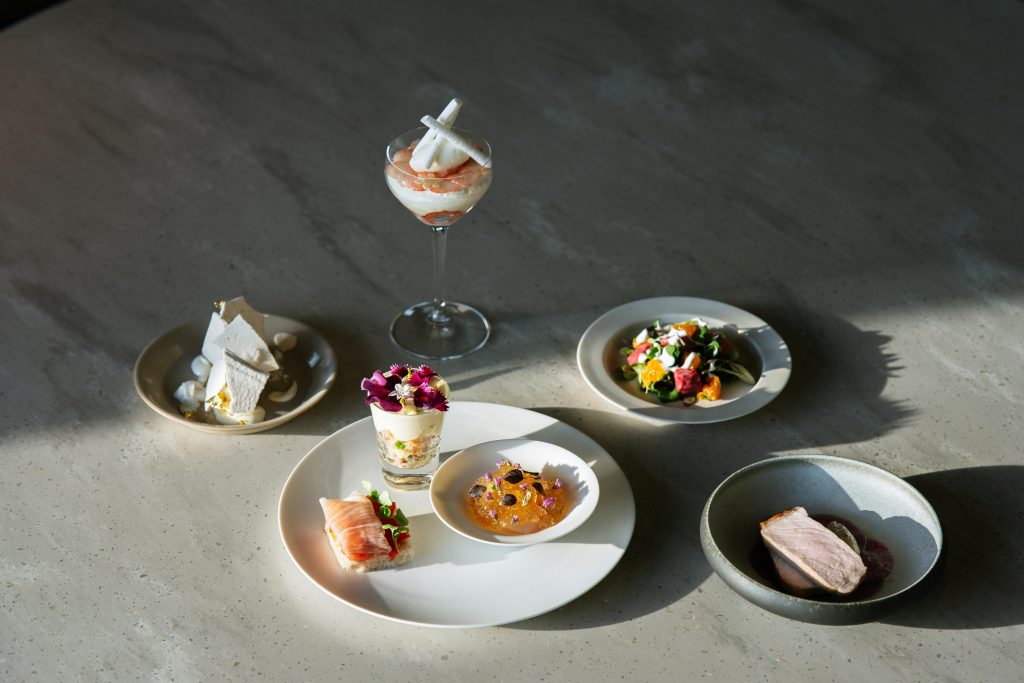 Luxurious gourmet food arrangement with diverse exquisite dishes beautifully plated on a table.